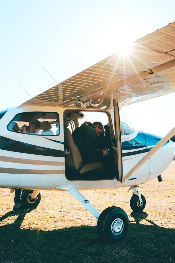 A pilot in a light aircraft preparing for takeoff under bright Canterbury sunlight.